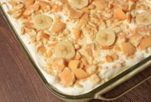 a white plate with a serving of dump cake with vanilla ice-cream on top.